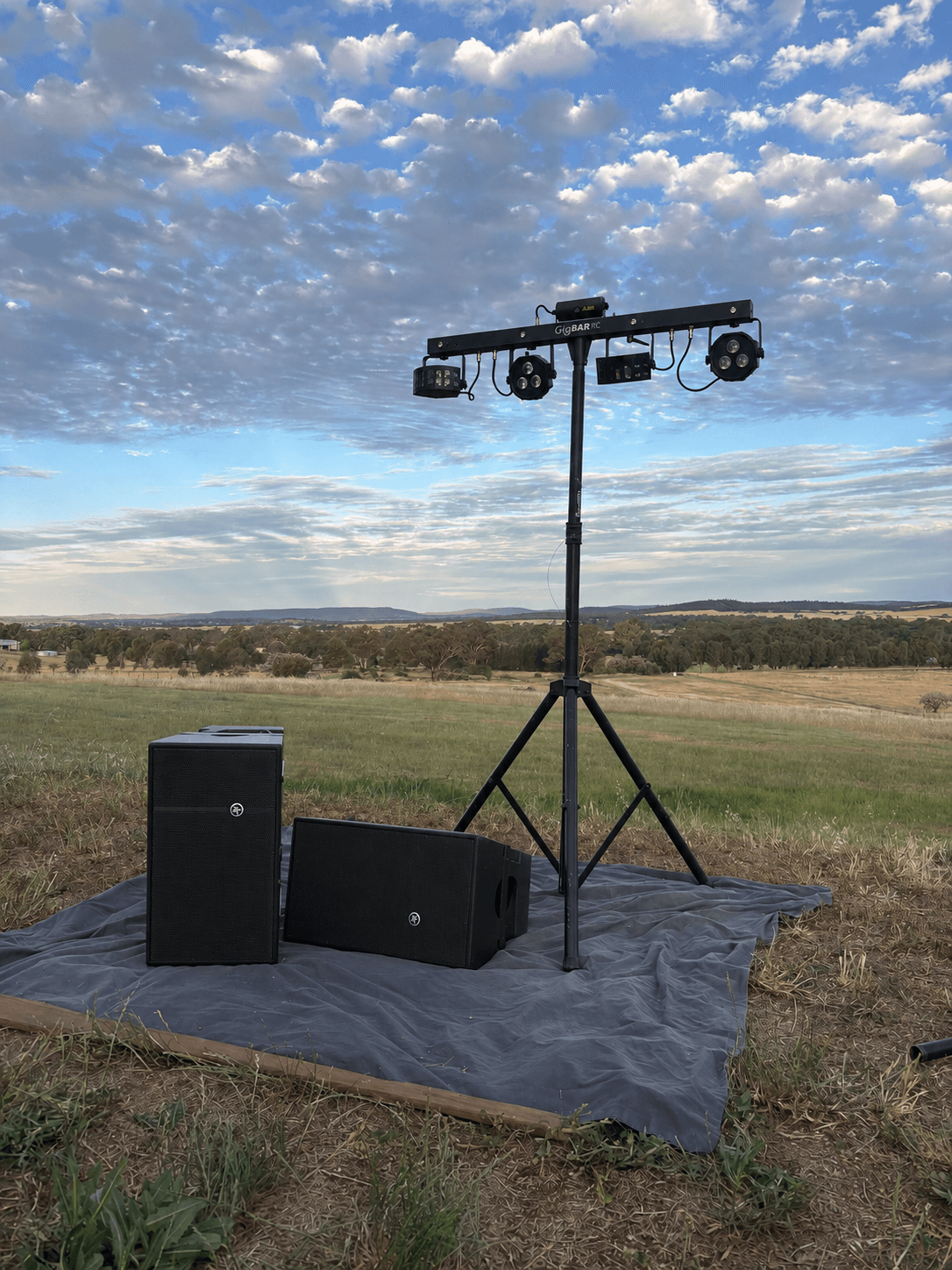 Chauvet GigBAR lighting on a tall stand beside a pair of Mackie HDA tops